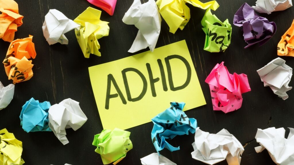 ADHD written with marker on paper with crumpled paper balls around it