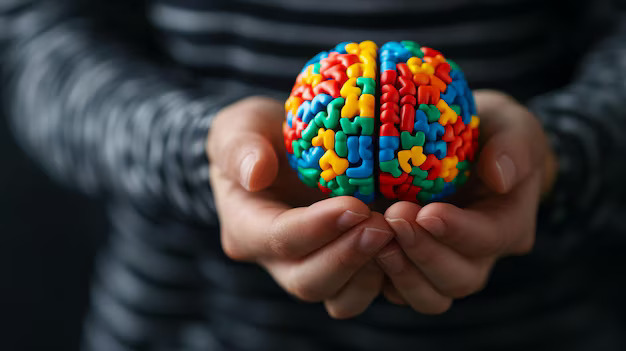 Person gently cradling a colorful brain model