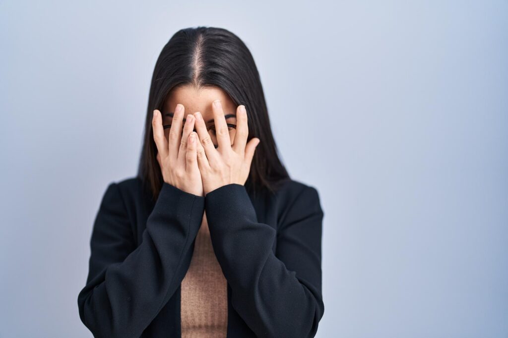 Woman with her hands covering her face